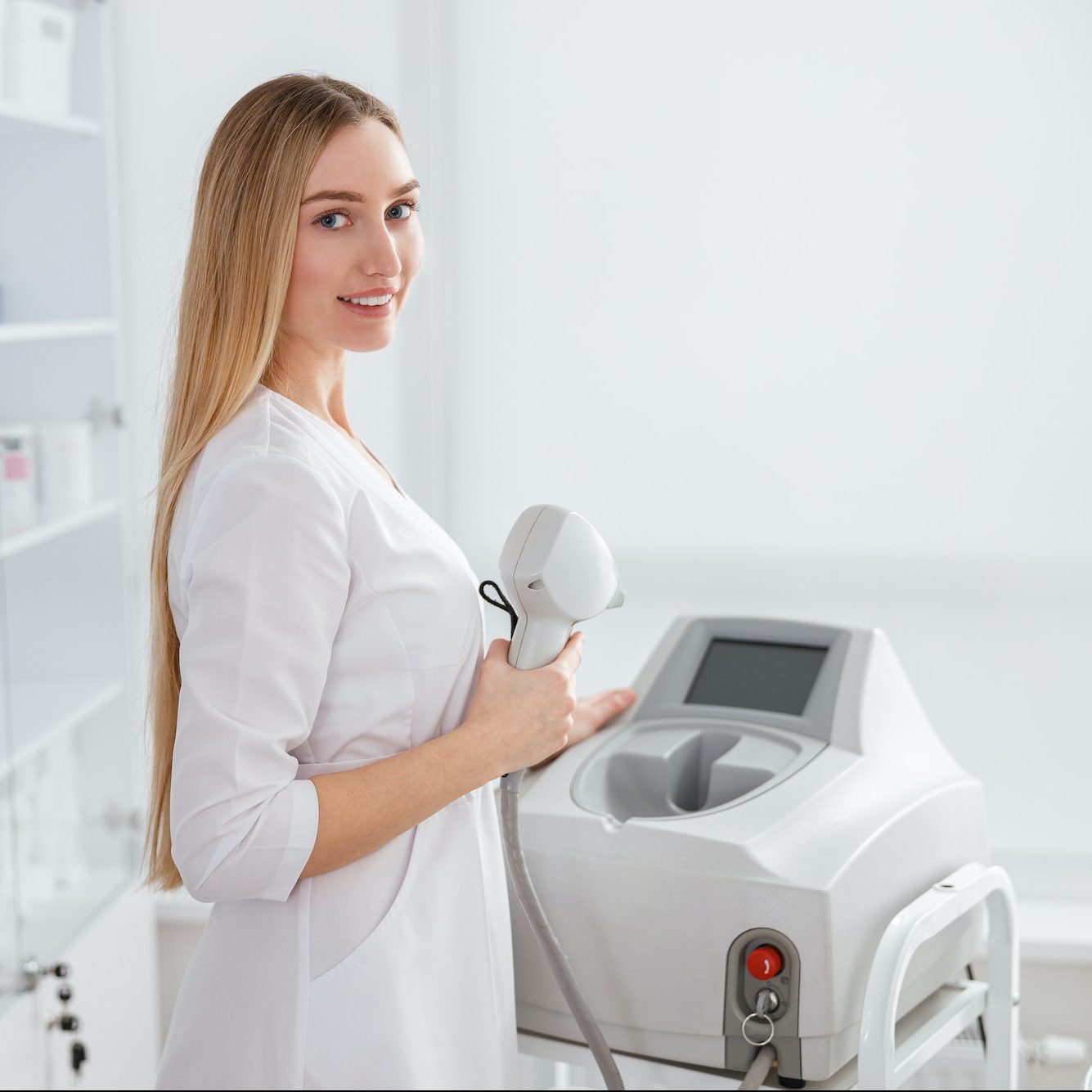 Young woman using laser epilation machine in beauty salon